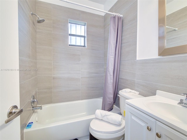 full bathroom featuring shower / bath combination with curtain, tile walls, toilet, and large vanity