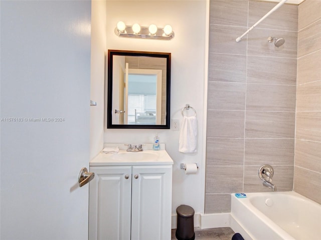 bathroom featuring tiled shower / bath and vanity