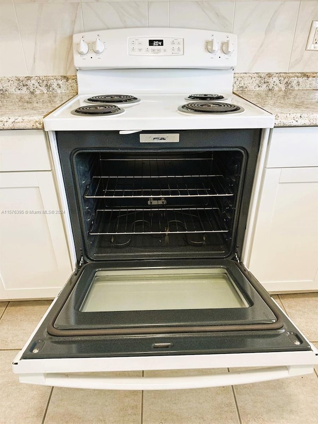 interior details featuring light tile floors and electric stove