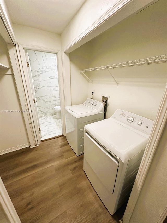 laundry area featuring wood-type flooring, washing machine and dryer, and hookup for a washing machine