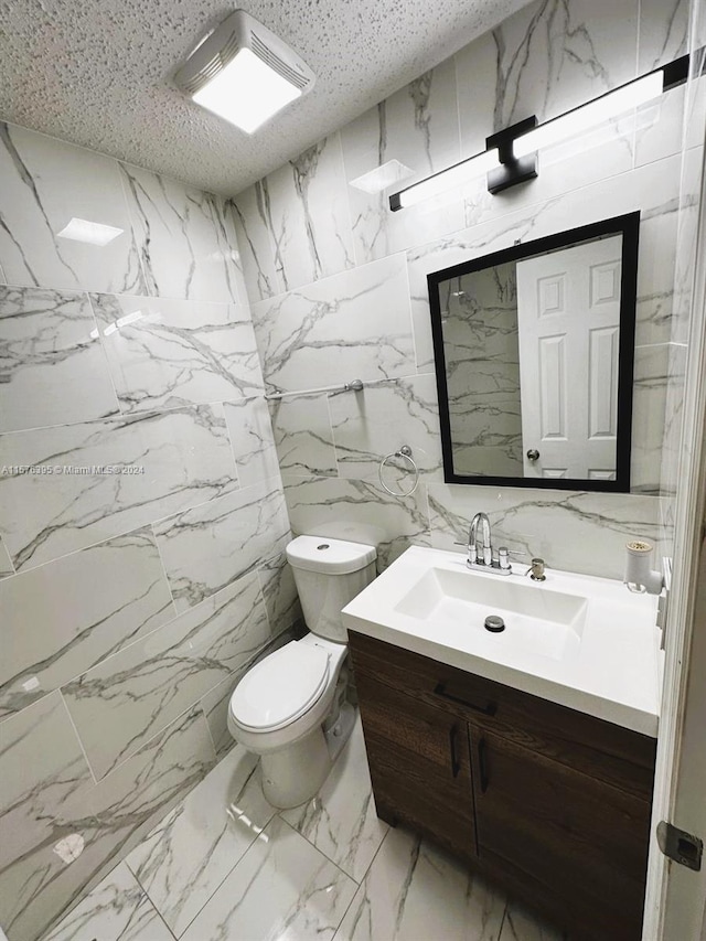 bathroom with oversized vanity, toilet, tile floors, and tile walls