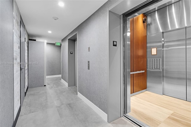 hall featuring light tile flooring and elevator