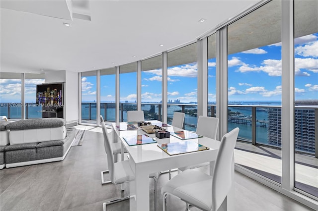 dining room with expansive windows and a water view