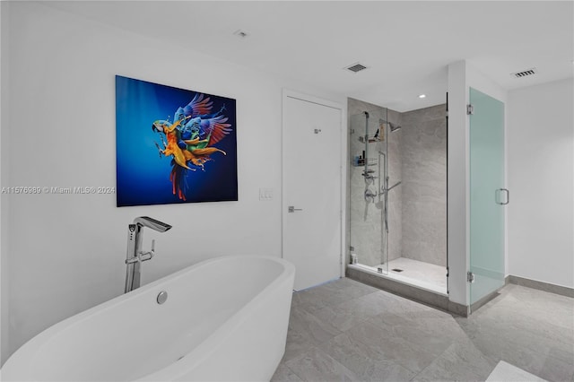 bathroom featuring shower with separate bathtub and tile flooring