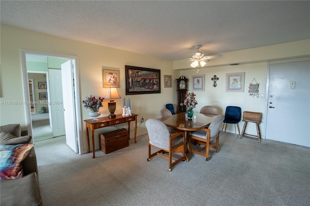 dining room featuring a textured ceiling, ceiling fan, and carpet