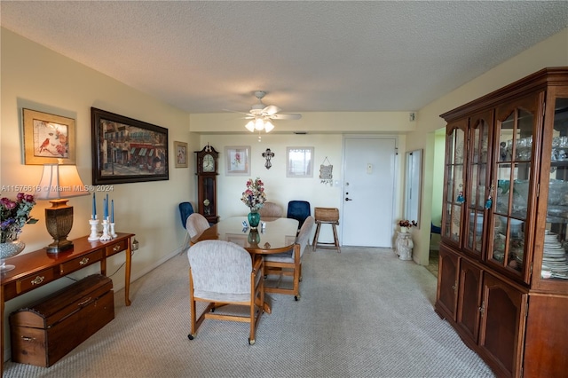 dining room featuring ceiling fan, carpet, and a textured ceiling