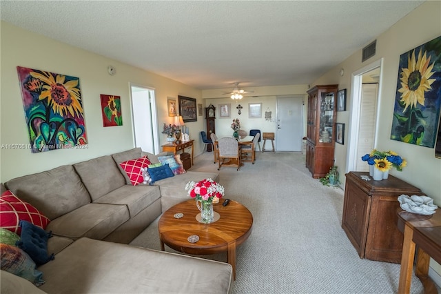 carpeted living room featuring a textured ceiling and ceiling fan