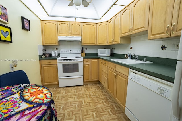 kitchen with sink, light parquet flooring, tasteful backsplash, and white appliances