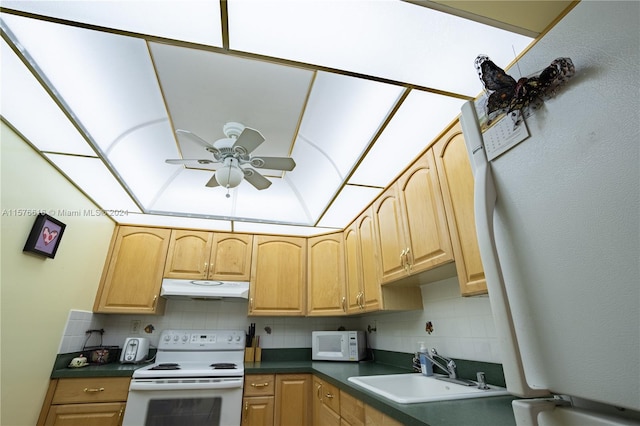 kitchen with backsplash, ceiling fan, white appliances, and sink