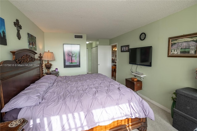 bedroom featuring a closet, a textured ceiling, and carpet