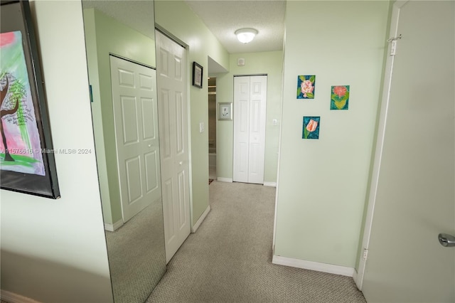 hallway featuring a textured ceiling and carpet