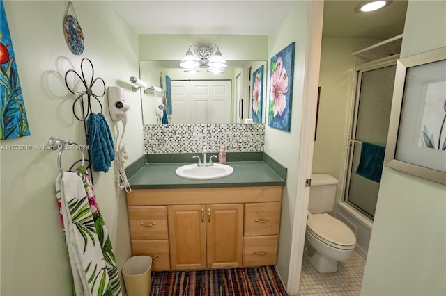 bathroom featuring backsplash, toilet, tile floors, and vanity