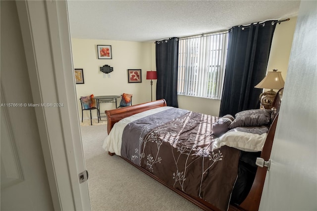 carpeted bedroom featuring a textured ceiling