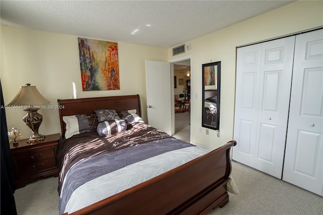 carpeted bedroom with a closet and a textured ceiling