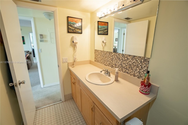 bathroom featuring backsplash, tile floors, and vanity