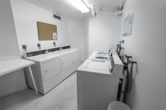 clothes washing area with washer and clothes dryer, hookup for a washing machine, light tile floors, and electric dryer hookup