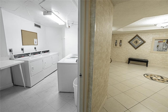 laundry room featuring hookup for an electric dryer, light tile floors, and separate washer and dryer