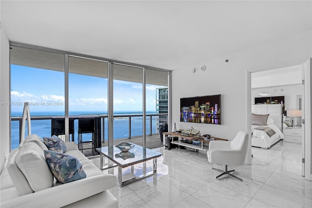 living room with a water view, floor to ceiling windows, and light tile floors