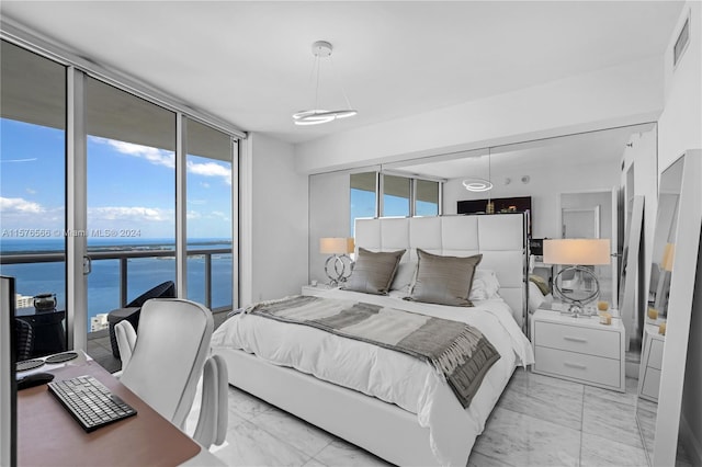 tiled bedroom featuring floor to ceiling windows, access to outside, and a water view