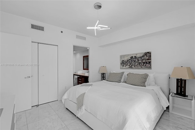 bedroom featuring ensuite bath, an inviting chandelier, light tile flooring, and a closet