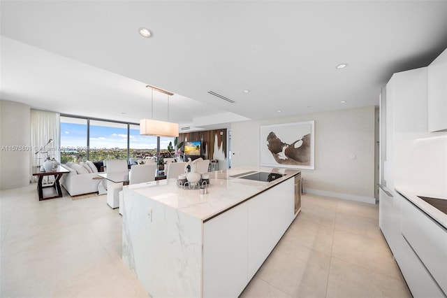 kitchen with a kitchen island, pendant lighting, white cabinetry, and light tile floors