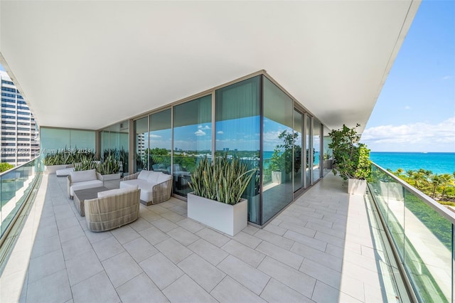 balcony with an outdoor living space and a water view