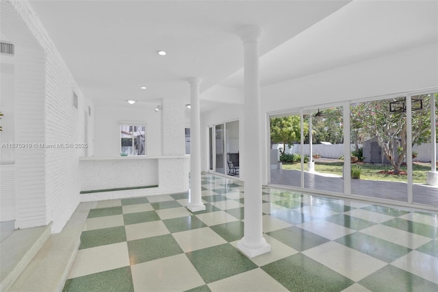 spare room with brick wall and ornate columns