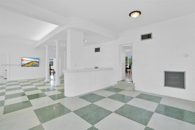 interior space with decorative columns and brick wall