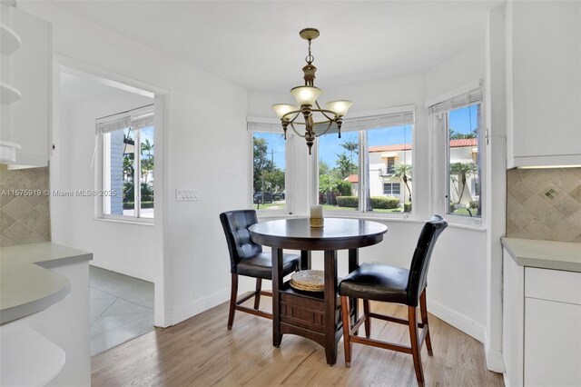 dining space with a chandelier and light hardwood / wood-style floors