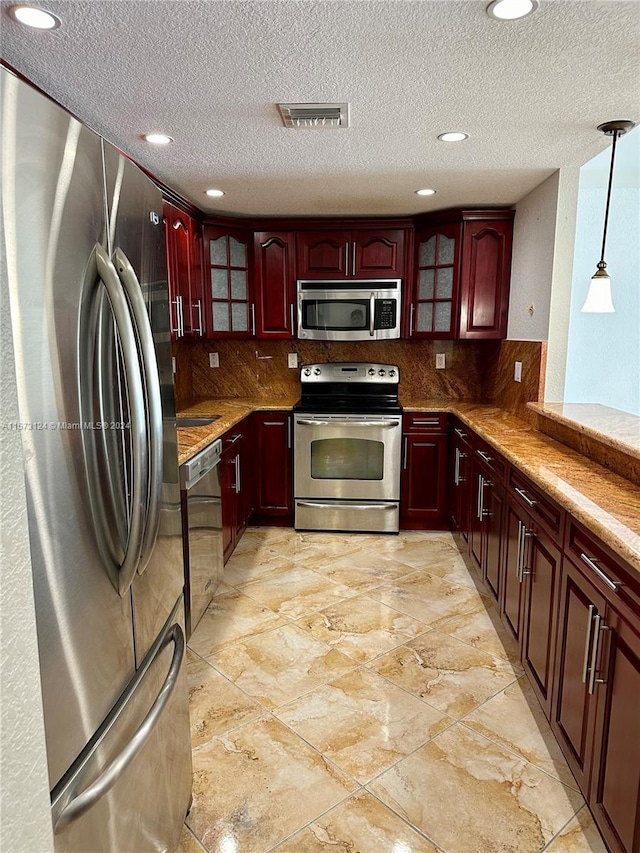 kitchen featuring light tile flooring, tasteful backsplash, pendant lighting, and stainless steel appliances