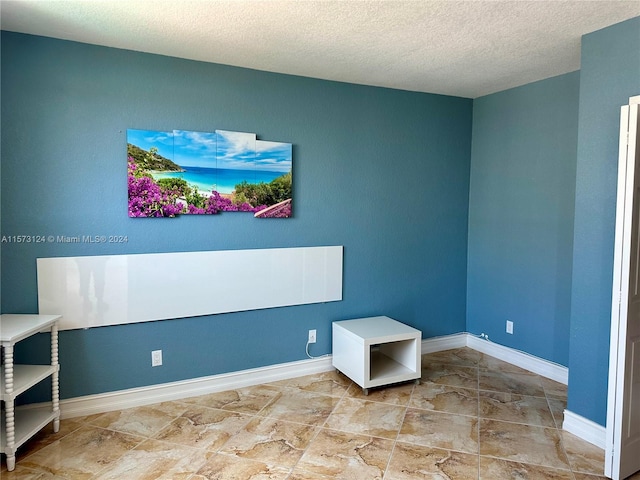 living area featuring tile floors and a textured ceiling