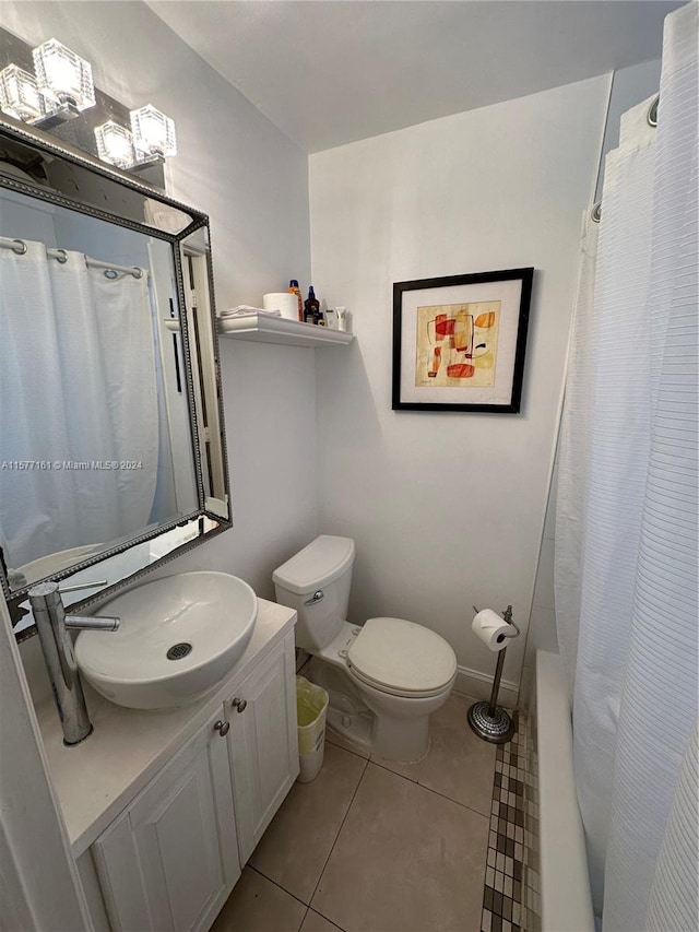 bathroom with tile flooring, large vanity, and toilet