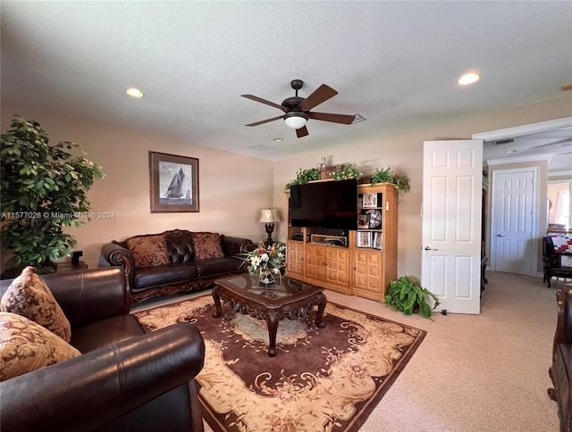 carpeted living room featuring a textured ceiling and ceiling fan