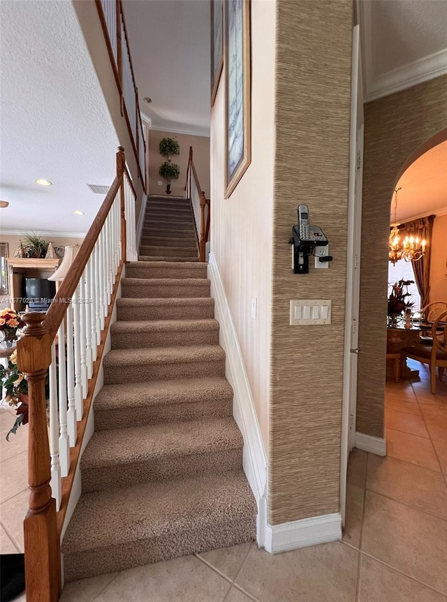 stairway with ornamental molding, a chandelier, and tile flooring