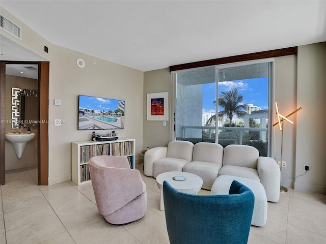 living room featuring a wall of windows and light tile patterned floors