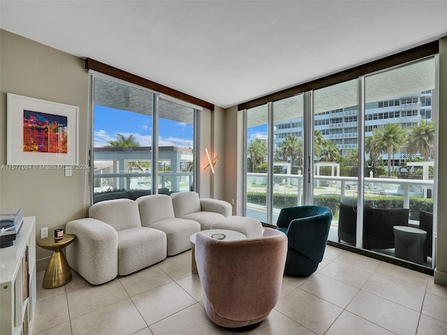 tiled living room featuring a wall of windows