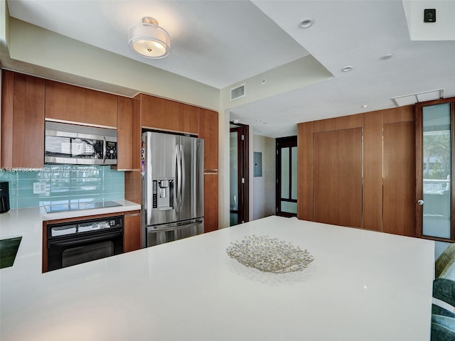 kitchen featuring electric panel, backsplash, black appliances, and kitchen peninsula