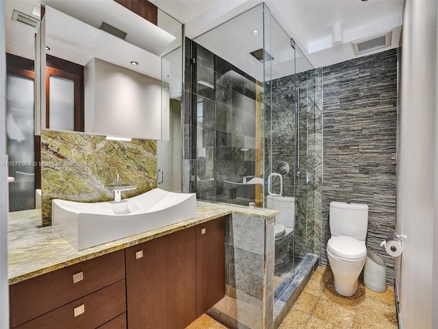 bathroom featuring vanity, walk in shower, tile walls, and toilet