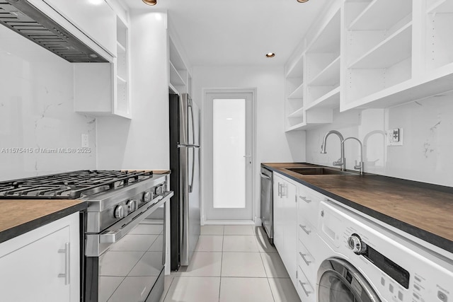 kitchen featuring sink, white cabinets, stainless steel appliances, and washer / dryer