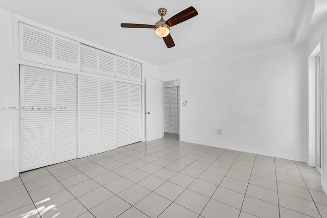 unfurnished bedroom with ceiling fan, light tile patterned floors, and a closet