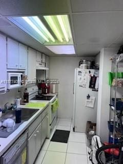 kitchen featuring sink, white appliances, and light tile floors