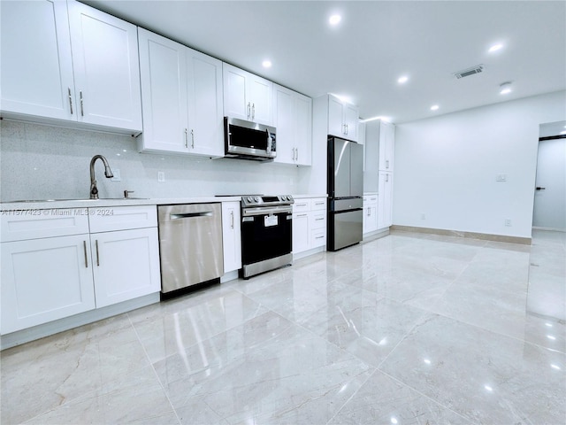 kitchen featuring light tile flooring, white cabinetry, backsplash, stainless steel appliances, and sink