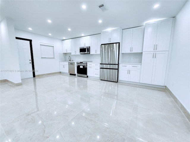 kitchen with white cabinetry, backsplash, appliances with stainless steel finishes, sink, and light tile floors