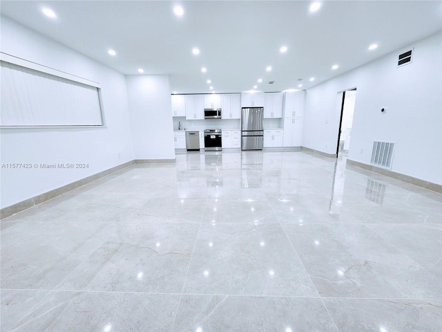 unfurnished living room featuring sink and light tile floors