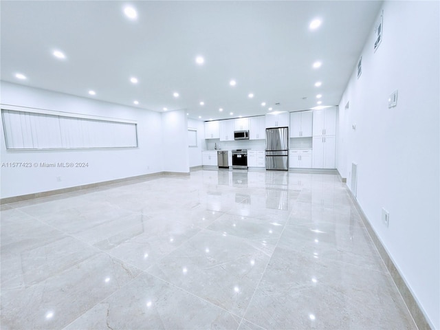 unfurnished living room featuring light tile flooring