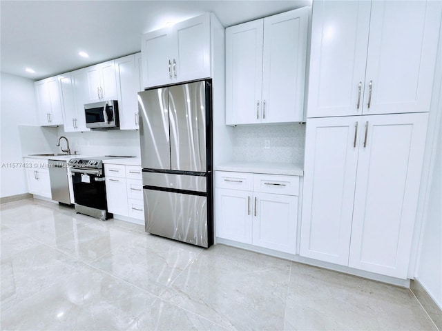 kitchen featuring sink, appliances with stainless steel finishes, light tile flooring, and white cabinetry