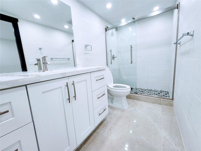 bathroom featuring a shower with door, tile floors, vanity, and toilet