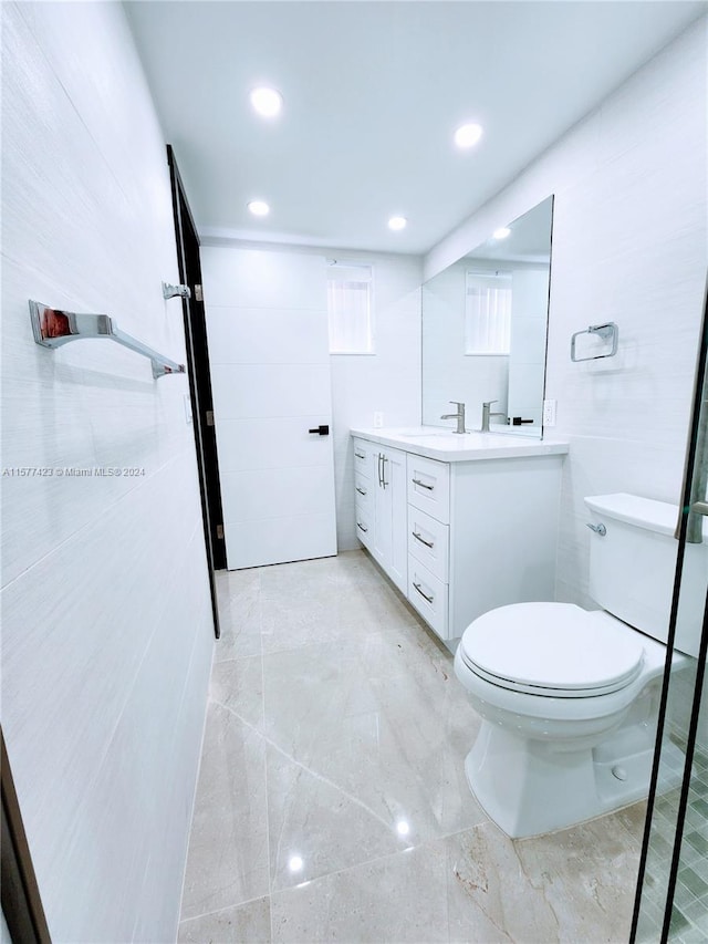 bathroom featuring toilet, tile floors, and dual vanity