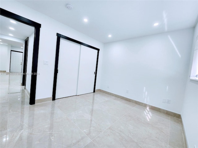 unfurnished bedroom with a closet and light tile floors