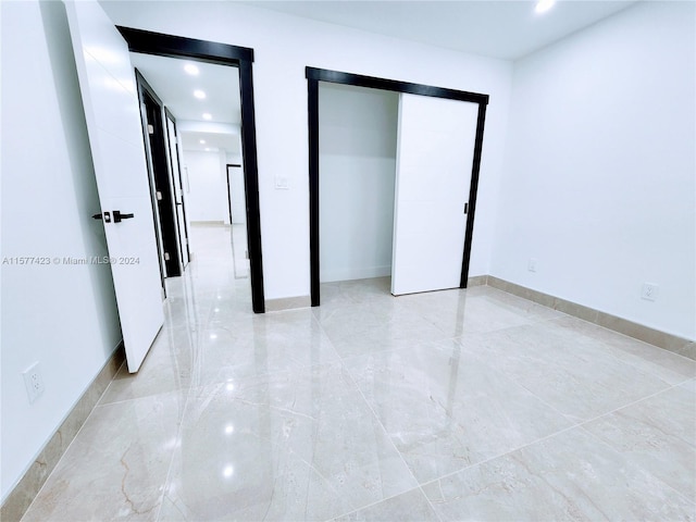 unfurnished bedroom with a closet and light tile flooring